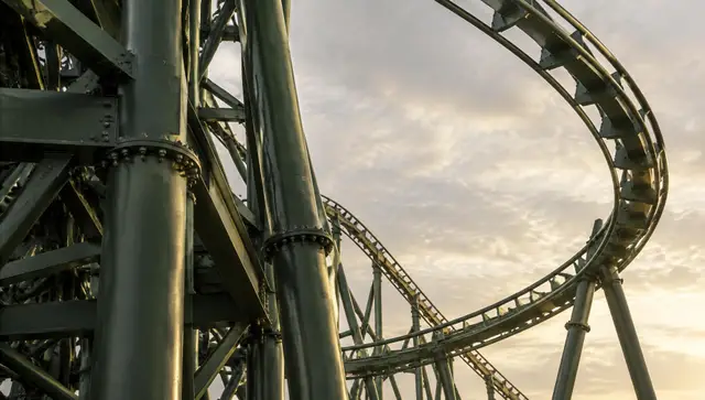 Steel supports and a looping roller coaster track at dusk, the rides this site covers